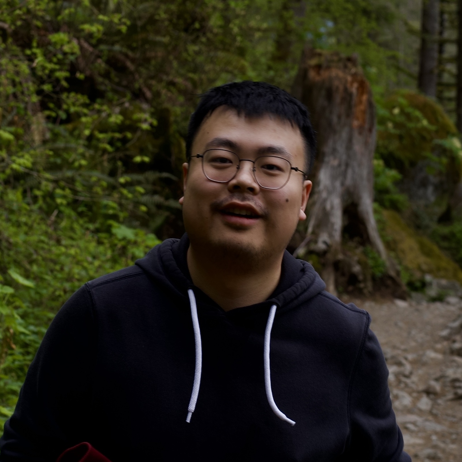 Zhuohao (Jerry) Zhang at CHI 2019 standing in front of a poster, wearing a black sweater.